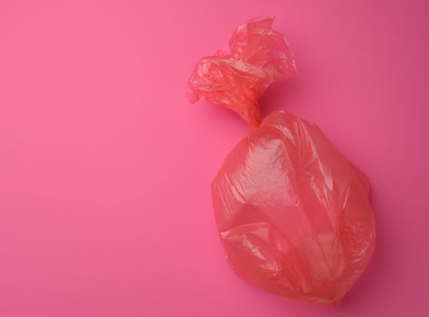 empty plastic trash bag on pink background photo