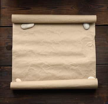 roll of brown kraft paper on a wooden background. Place for an inscription photo