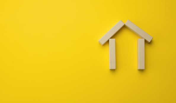wooden miniature house on a yellow background. The concept of buying and selling a house, renting and leasing real estate photo