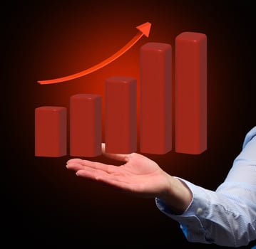 growing graph from red cubes and a woman's hand. The concept of business growth, high profitability, growing dynamics of indicators photo