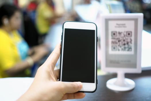 Hands use the phone to scan the QR code to accumulate points before paying at the counter. photo
