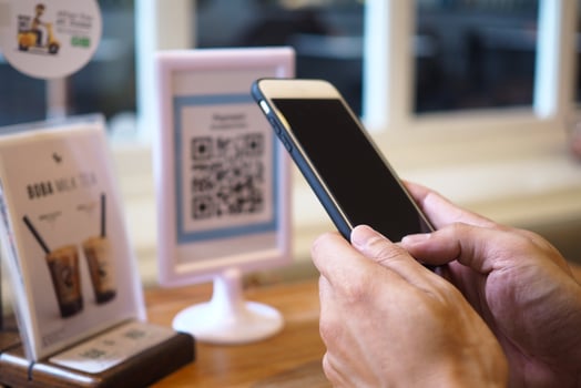 Hands use the phone to scan QR codes to accumulate points in restaurants. photo