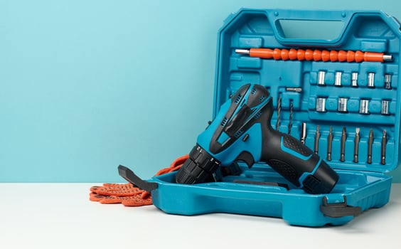 plastic box with cordless drill and set of drills and screwdrivers on white background photo