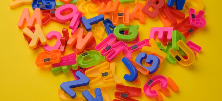 multicolored plastic english alphabet letters with magnet on yellow background photo