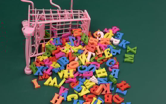 scattered multicolored letters of the english alphabet from a miniature shopping cart photo