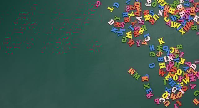 multicolored wooden letters of the english alphabet on a green background, top view photo