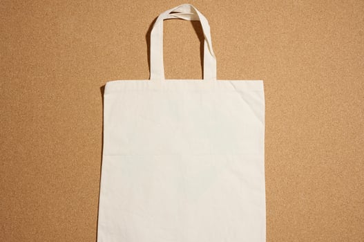 empty linen eco friendly beige canvas tote bag for branding on brown background. Clear reusable bag for groceries, mock up. Flat lay photo
