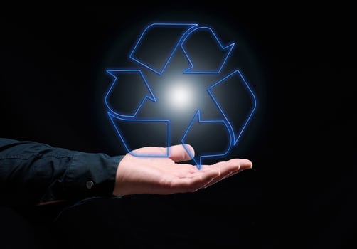 Blue glowing recycling sign floating above hand, sustainable development. Ecology and environment concept. photo