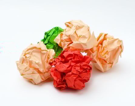 multicolored crumpled paper balls on white background photo