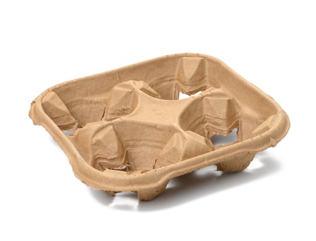 square cardboard holder made from recycled ecological raw materials for four cups of coffee or tea on a white isolated background photo