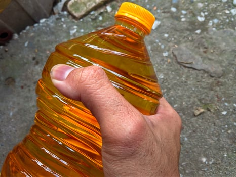 Male hand holding a bottle of cooking oil photo