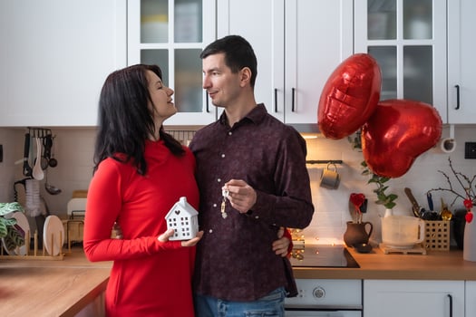 Man and woman in love date at home in kitchen with keys of house. Valentine's Day, happy couple, love story. Love nest, mortgage, relocation, purchase, real estate, housing for young family photo
