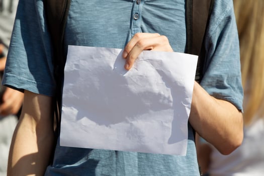 Man's hands hold a blank white sheet of paper. photo