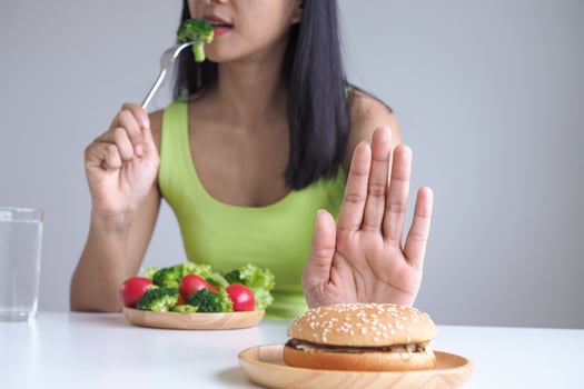Healthy women choose to eat vegetable trays and refuse to eat hamburgers. photo