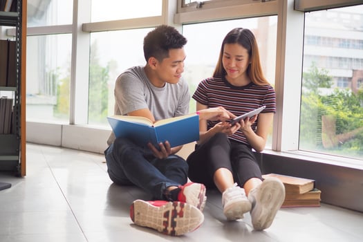 Two students study and read together in the library. photo