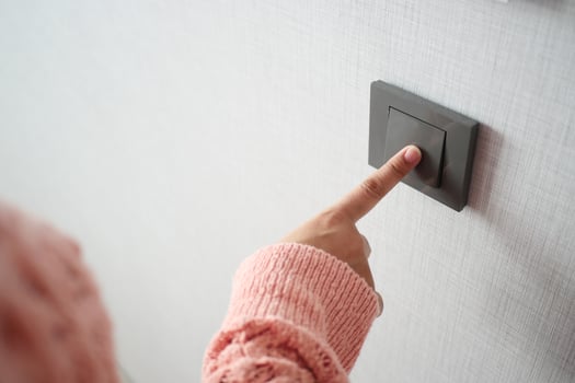 women finger turning on lighting switch . photo