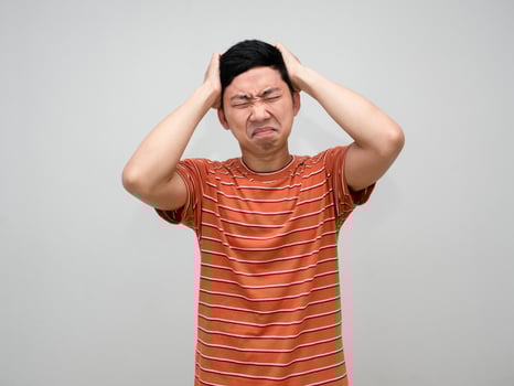 Asian man striped shirt feels headache from hard working isolated photo