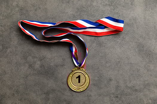 Simply flat lay design winner or champion gold trophy medal on concrete stone grey background. Victory first place of competition. Winning or success concept. Top view flat lay copy space. photo