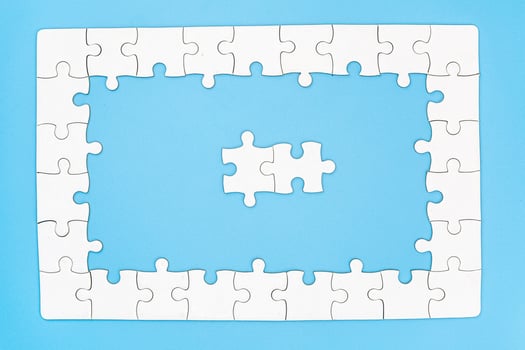 white jigsaw puzzle pieces on blue background,  Copy space. photo