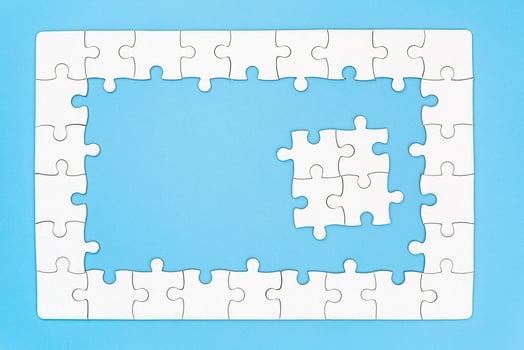 Unfinished white jigsaw puzzle pieces on blue background, The last piece of jigsaw puzzle, Copy space. photo