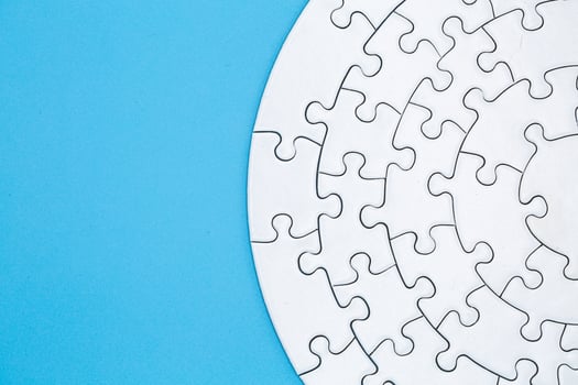 white jigsaw puzzle pieces on blue background,  Copy space. photo