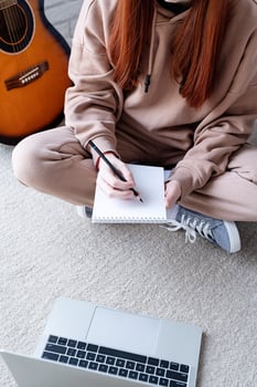 Young woman learning to play guitar at home photo