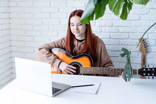 Young woman learning to play guitar at home photo
