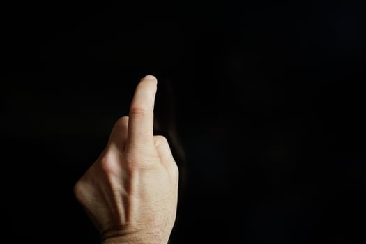index finger pointing at the screen, black background photo
