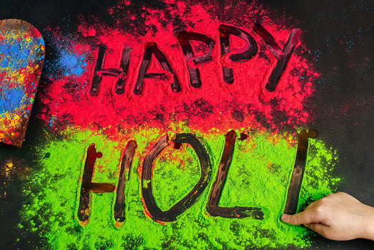 Happy holi inscription children's hand writes. .Holi background with colored powder. photo