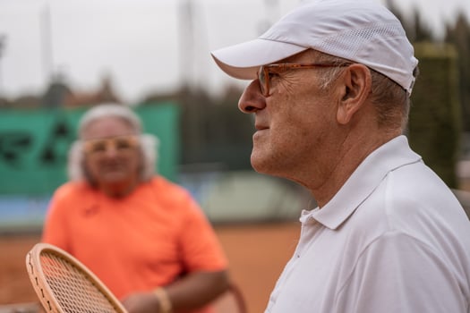 portrait of two senior tennis players dressed in sportswear relaxing at the end of the game on a clay tennis court photo