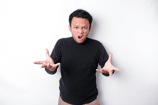 The angry and mad face of Asian man in black shirt isolated white background. photo