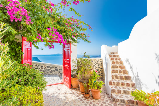 Traditional white architecture and red door overlooking the Mediterranean sea in Oia Village on Santorini Island, Greece. Scenic summer travel and vacation background. Luxury tourism background photo