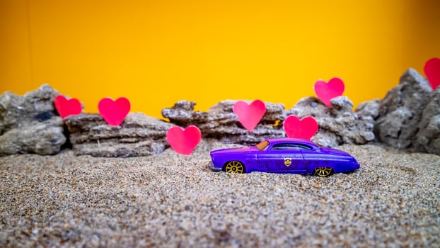 Minahasa, Indonesia  December 2022, toy car with gradient orange background and a heart photo