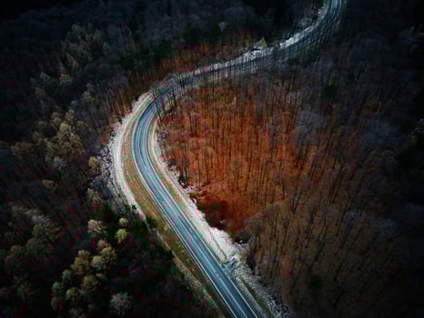 Landscape with winding road through forest, aerial view photo