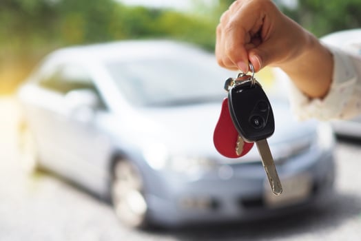 The car owner is standing the car keys to the buyer. Used car sales photo
