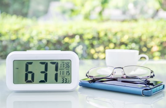 Digital clock and eyeglass with coffee cup photo