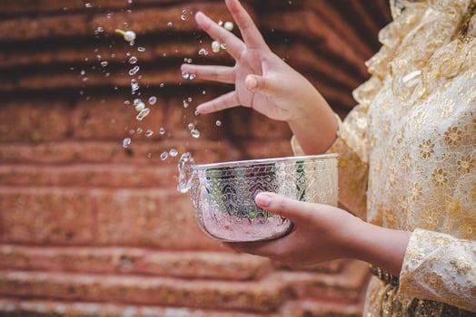 Female hands holding water bowl on Songkran festival photo