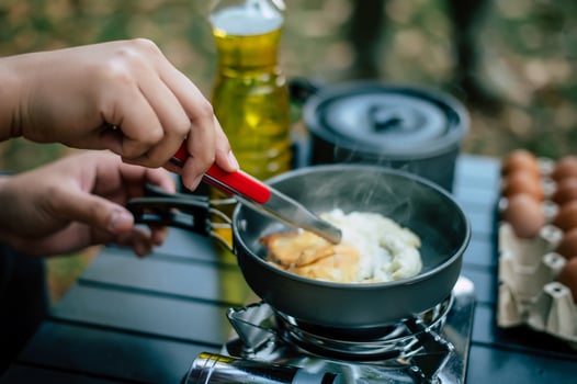 Portrait of Asian traveler man glasses frying a tasty fried egg photo