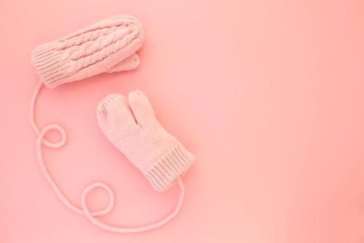 Close-up pink mittens and shaped of string on pink background. Lifestyle and warm feelings concept. Valentine day. Monocolor romantic pattern. Winter theme. Flat lay composition. Top view. Copy space photo