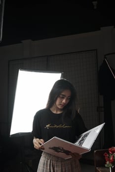 Asian woman from Indonesia reading a book against a light background photo