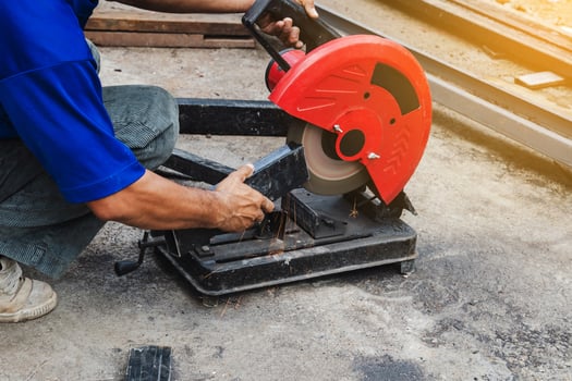 Worker man cutting steel with a circular steel cutter. photo