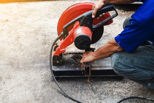 Worker man cutting steel with a circular steel cutter. photo