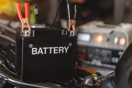 Charging motorcycle battery at garage, selective focus on Alligator clip ,concept of motorcycle maintenance and repair. photo