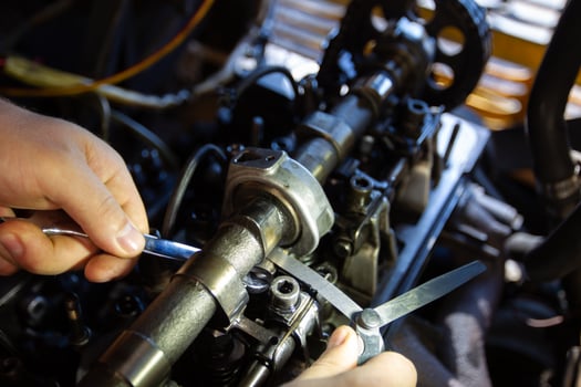 Mercedes diesel engine repair. Hands with a mechanic repairing Mercedes parts. Valve clearance adjustment. photo