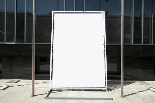 An empty advertising banner stands on a city street. photo
