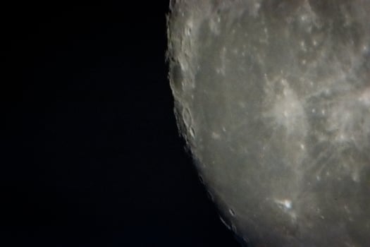 moon through telescope in black sky photo