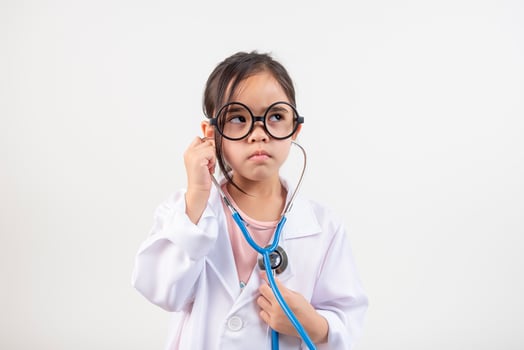 Asia little girl playing doctor isolated on white photo