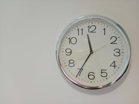 clock hanging on the white wall with copy space photo