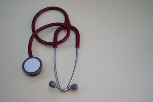 Red stethoscope on white background in clinic photo