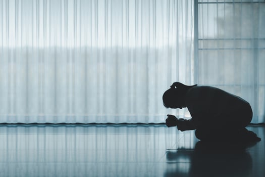 silhouette of woman kneeling and praying in modern church at sunset time. Female catholic prayer worship to God wish a better life in home at dawn with believe faith. concept of worshipers kneeling. photo